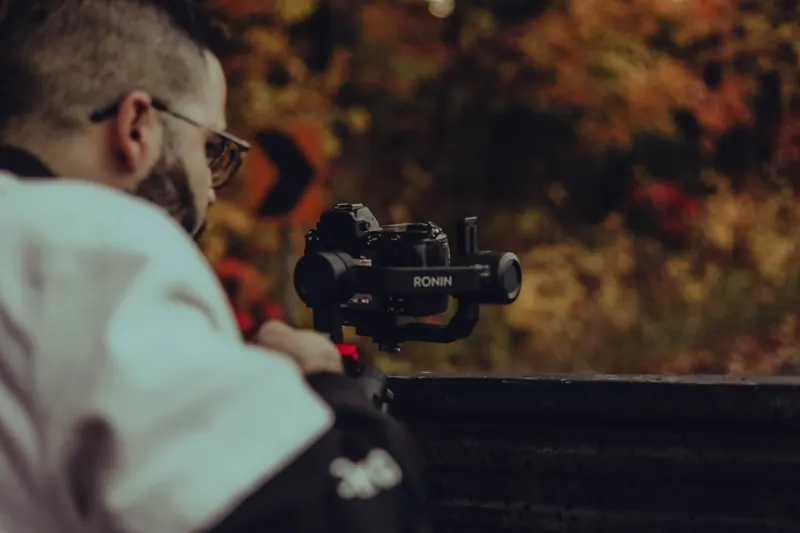 Jason Mikhow filming with a gimbal outdoors in the fall